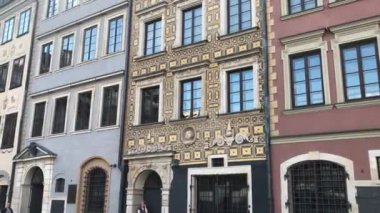 Warszawa, Polonya, penceresinin önünde saati olan büyük bir tuğla bina.