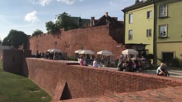 Warszawa, Polônia, Um grupo de pessoas em frente a um prédio de tijolos — Vídeo de Stock