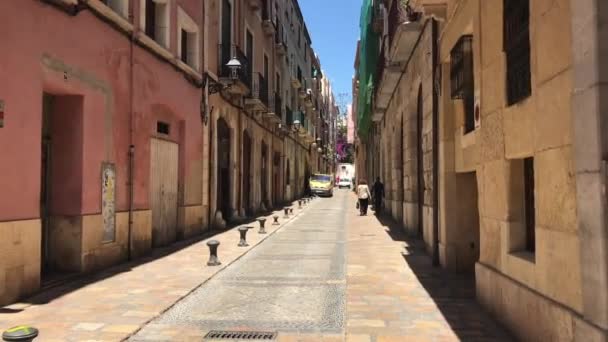 Tarragona, España, Una calle de ciudad estrecha con edificios antiguos en el fondo — Vídeo de stock