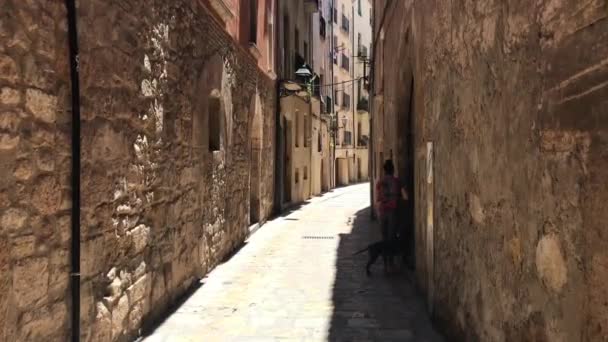 Tarragona, España, Un edificio de piedra que tiene un cartel en una acera de ladrillo — Vídeo de stock