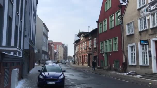 Gdansk, Polonia, Una estrecha calle de la ciudad con coches aparcados en el lado de un edificio — Vídeos de Stock