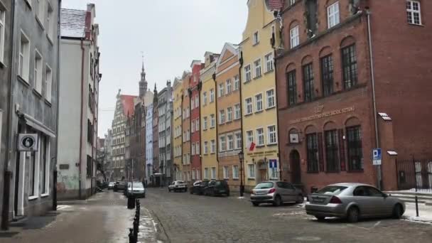 Gdańsk, Polska, Wąska ulica miejska z samochodami zaparkowanymi po stronie budynku — Wideo stockowe