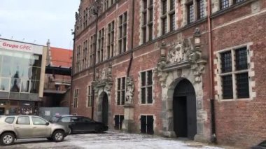 Gdansk, Polonya, tuğla bir binanın önüne park edilmiş bir araba.