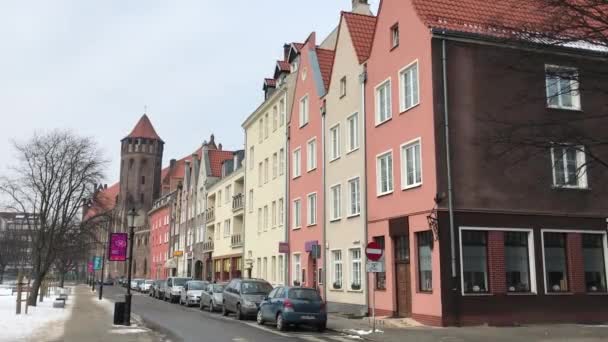 Gdańsk, Polska, Wąska ulica miejska z samochodami zaparkowanymi po stronie budynku — Wideo stockowe