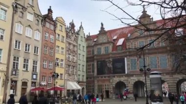 Gdansk, Polonya, bir grup insan bir binanın önünde yürüyor.