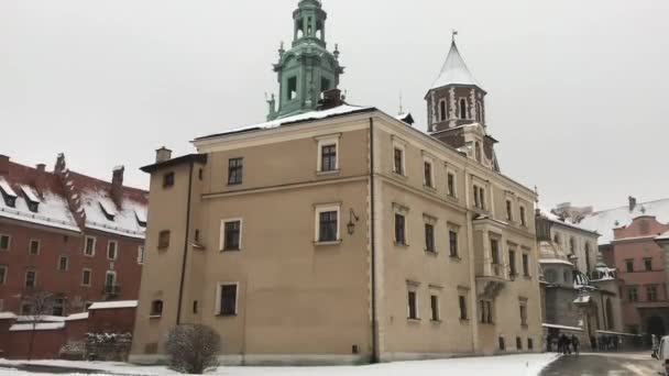 Krakow, Polonya, Binanın kenarında saati olan bir kilise — Stok video