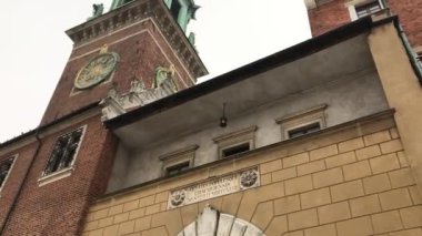 Krakow, Polonya, tuğla bir binanın önündeki saat kulesi