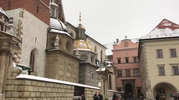 Cracovia, Polonia, Un gruppo di persone che camminano davanti a un edificio di mattoni — Video Stock