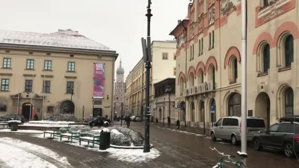 Krakkó, Lengyelország, forgalmas városi utca, egy épület oldalán parkoló autókkal — Stock videók