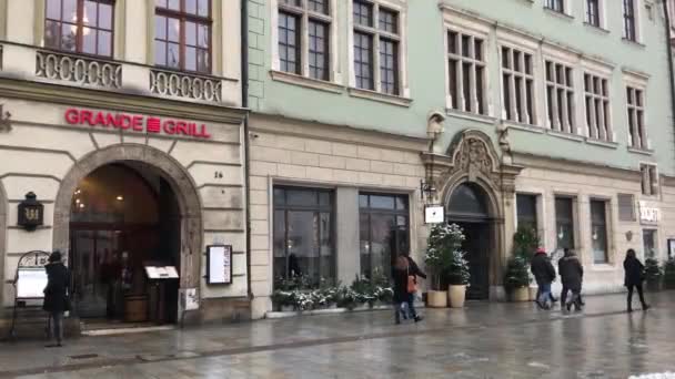 Kraków, Polska, Grupa osób spacerujących przed budynkiem — Wideo stockowe