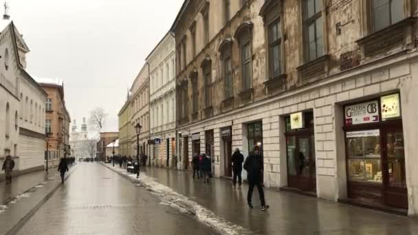 Cracovia, Polonia, Una persona caminando por una calle al lado de un edificio — Vídeo de stock