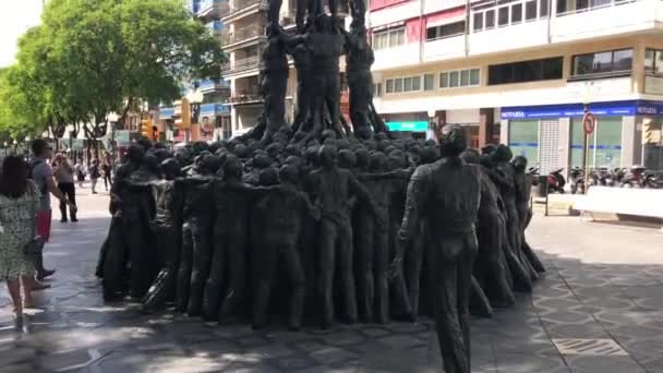 2018 년 6 월 30 일에 확인 함 . Tarragona, Spain, June 30, 2019: A group of people walk in front of a statue — 비디오