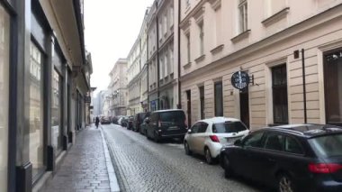 Krakow, Polonya, yol kenarında arabaların park ettiği dar bir şehir caddesi.