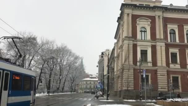 Krakau, Polen, Een dubbeldeksbus die door een straat voor een gebouw rijdt — Stockvideo
