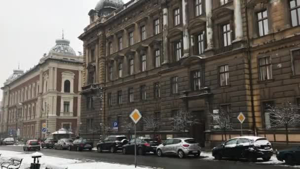 Cracovia, Polonia, Una strada trafficata città con auto parcheggiate sul lato di un edificio — Video Stock