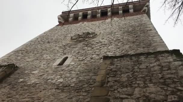 Cracóvia, Polónia, uma grande torre de tijolos com um relógio ao lado de um edifício — Vídeo de Stock