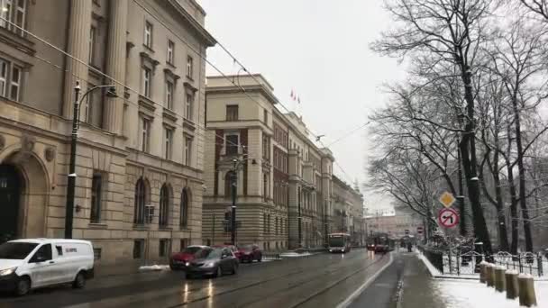 Kraków, Polska, Wąska ulica miejska z samochodami zaparkowanymi po stronie budynku — Wideo stockowe