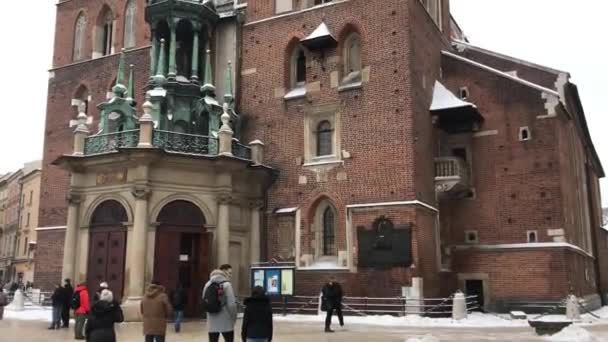 Krakow, Polandia, 20 Februari 2017: Sekelompok orang berjalan di depan sebuah bangunan bata — Stok Video
