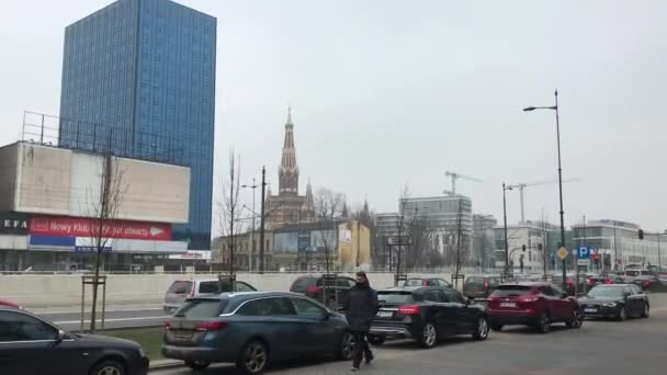 Lodz, Polonia, Un coche estacionado en una calle de la ciudad llena de tráfico rodeado de edificios altos — Vídeos de Stock