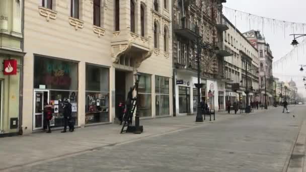 Lodz, Polônia, Um grupo de pessoas andando em uma rua da cidade — Vídeo de Stock