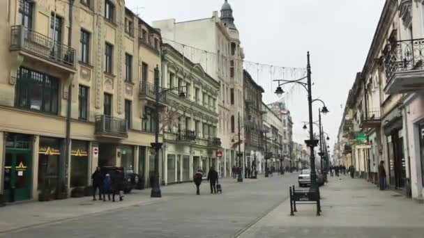Lodz, Lengyelország, Egy csoport ember sétál a város utcáin — Stock videók