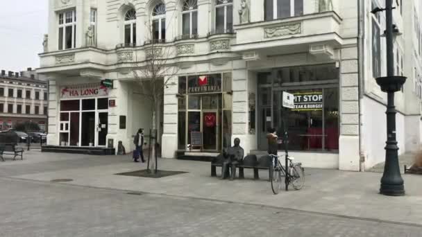 Lodz, Polônia, Uma pessoa andando por uma rua em frente a um prédio — Vídeo de Stock