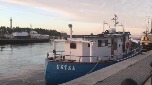 Ustka, Polonia, Un barco está atracado junto a un cuerpo de agua — Vídeo de stock