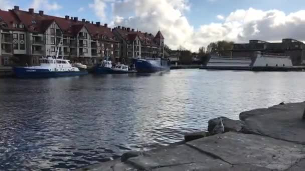 Ustka, Polonya, arkasında binalar olan büyük bir su kütlesi. — Stok video