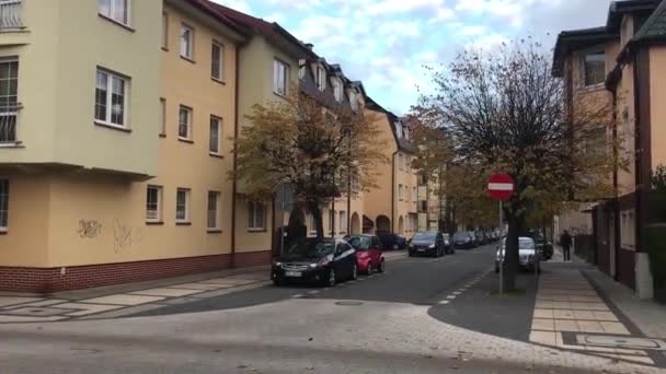 ポーランドのウシュカレンガ造りの建物の前の通りを歩いている人たち — ストック動画