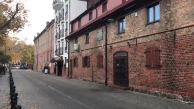 Ustka, Polonya, tuğla bir binanın önündeki sokağa yakın çekim.