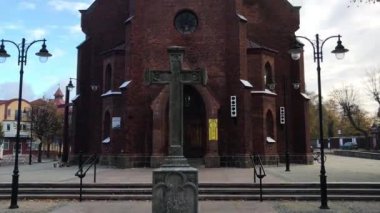 Ustka, Polonya, Caddenin kenarında saati olan bir bina.