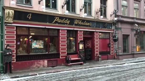 Riga, Letonia, Una tienda en un edificio de ladrillo con Temple Bar, Dublín en el fondo — Vídeo de stock