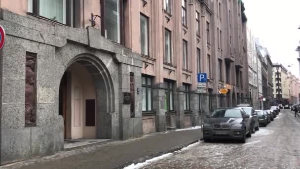 Riga, Letônia, Uma rua estreita da cidade com carros estacionados no lado de um edifício — Vídeo de Stock