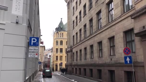 Riga, Lettland, En stadsgata med bilar parkerade på sidan av en byggnad — Stockvideo