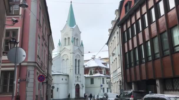 Riga, Letland, Een smalle straat met auto 's geparkeerd aan de zijkant van een gebouw — Stockvideo