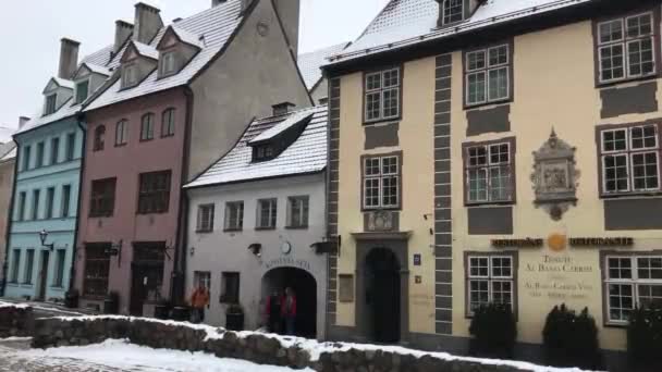 Riga, Lettonia, Una casa coperta di neve di fronte a un edificio — Video Stock