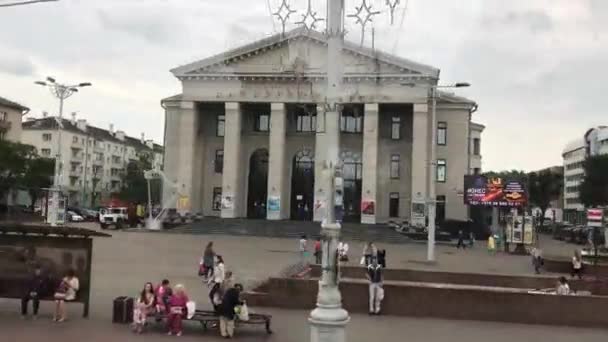 Minsk, Vitryssland, En grupp människor som går längs en gata bredvid en byggnad — Stockvideo