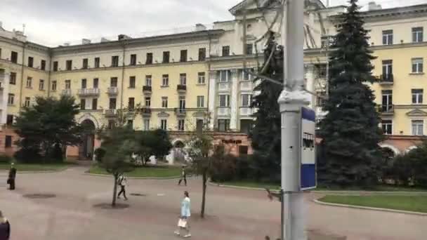 Minsk, Valko-Venäjä, ryhmä ihmisiä seisomassa rakennuksen edessä — kuvapankkivideo
