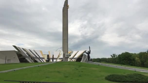 Minsk, Biélorussie, Une tour d'horloge au sommet d'un champ couvert d'herbe — Video