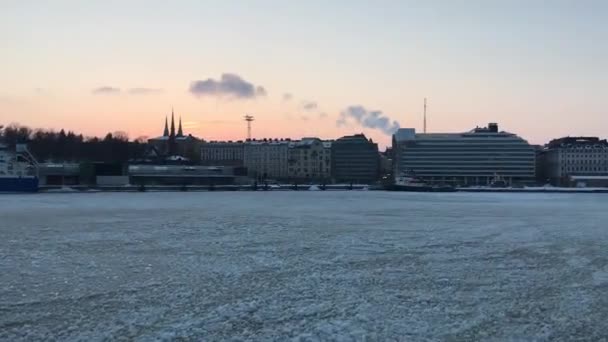 Helsinki, Finlandiya, arka planda bir şehir bulunan büyük bir su kütlesi — Stok video