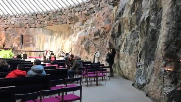 Helsinki, Finlandia, Grupa ludzi stojąca obok kamiennego muru — Wideo stockowe