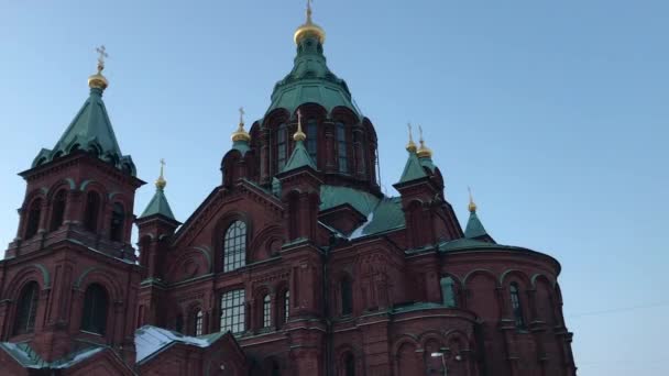 Helsinki, Finlandia, Una gran torre de reloj frente a un edificio — Vídeos de Stock