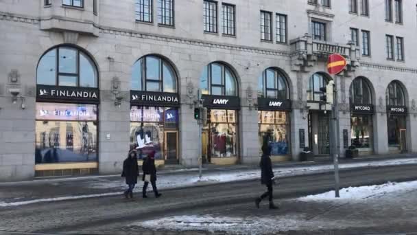 Helsinki, Finlandia, 20 lutego 2017: Grupa ludzi idących ulicą przed budynkiem — Wideo stockowe