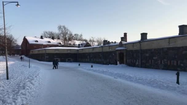 Helsinki, Finland, Een persoon die op een snowboard over een besneeuwde weg rijdt — Stockvideo