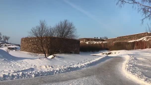 Helsinki, Finlandia, Un hombre montando una tabla de snowboard por un camino cubierto de nieve — Vídeo de stock