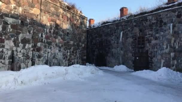 Helsinki, Finlandia, Una casa cubierta de nieve frente a un edificio de ladrillo — Vídeo de stock