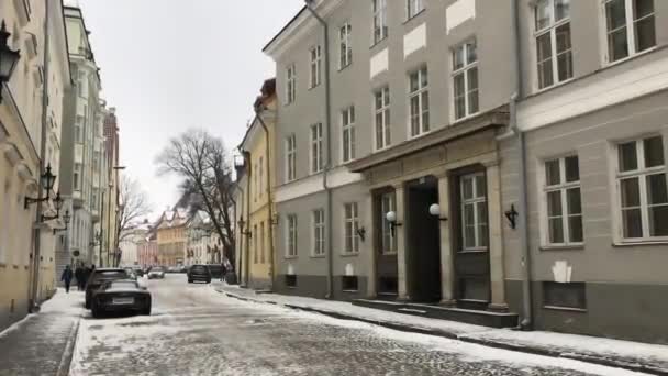 Tallinn, Estonya, bir binanın kenarına park etmiş arabalarla dolu bir şehir caddesi. — Stok video