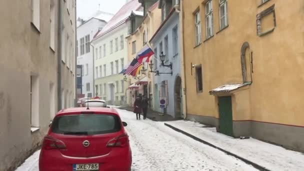 Tallinn, Estonya, karla kaplı bir caddenin kenarına park edilmiş bir araba. — Stok video