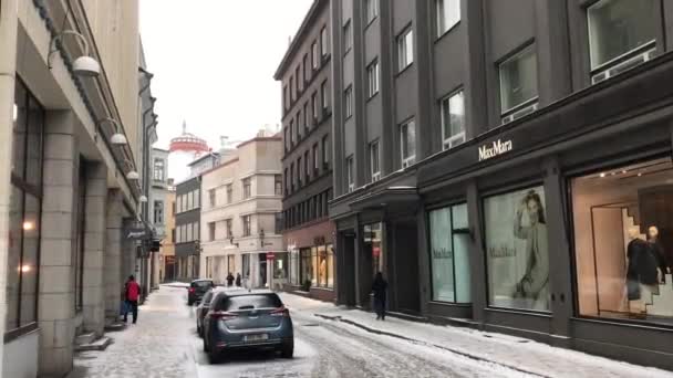 Tallinn, Estonya, bir binanın kenarına park edilmiş arabalarla dolu dar bir şehir caddesi. — Stok video