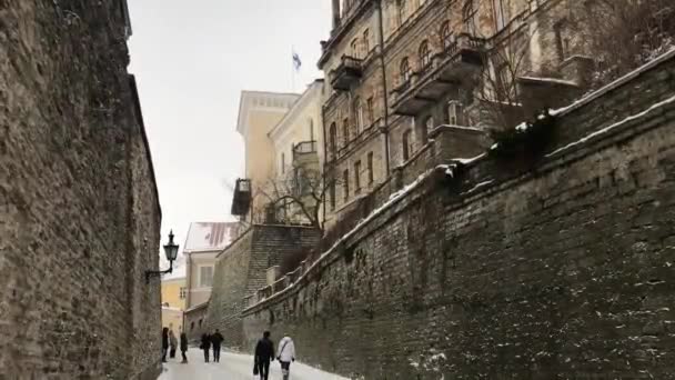 Tallinn, Estonsko, skupina lidí kráčející po ulici vedle cihlové budovy — Stock video